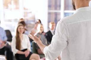 person speaking in front of office audience